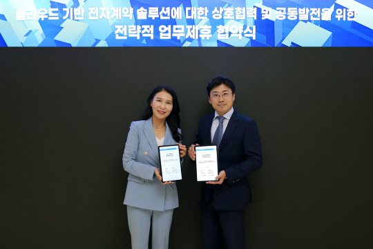 박미경(왼쪽) 포시에스 대표와 이주완 메가존클라우드 대표가 포시에스 '이폼사인'으로 작성한 협약서에 서명한 후 기념촬영하고 있다. 양사 제공